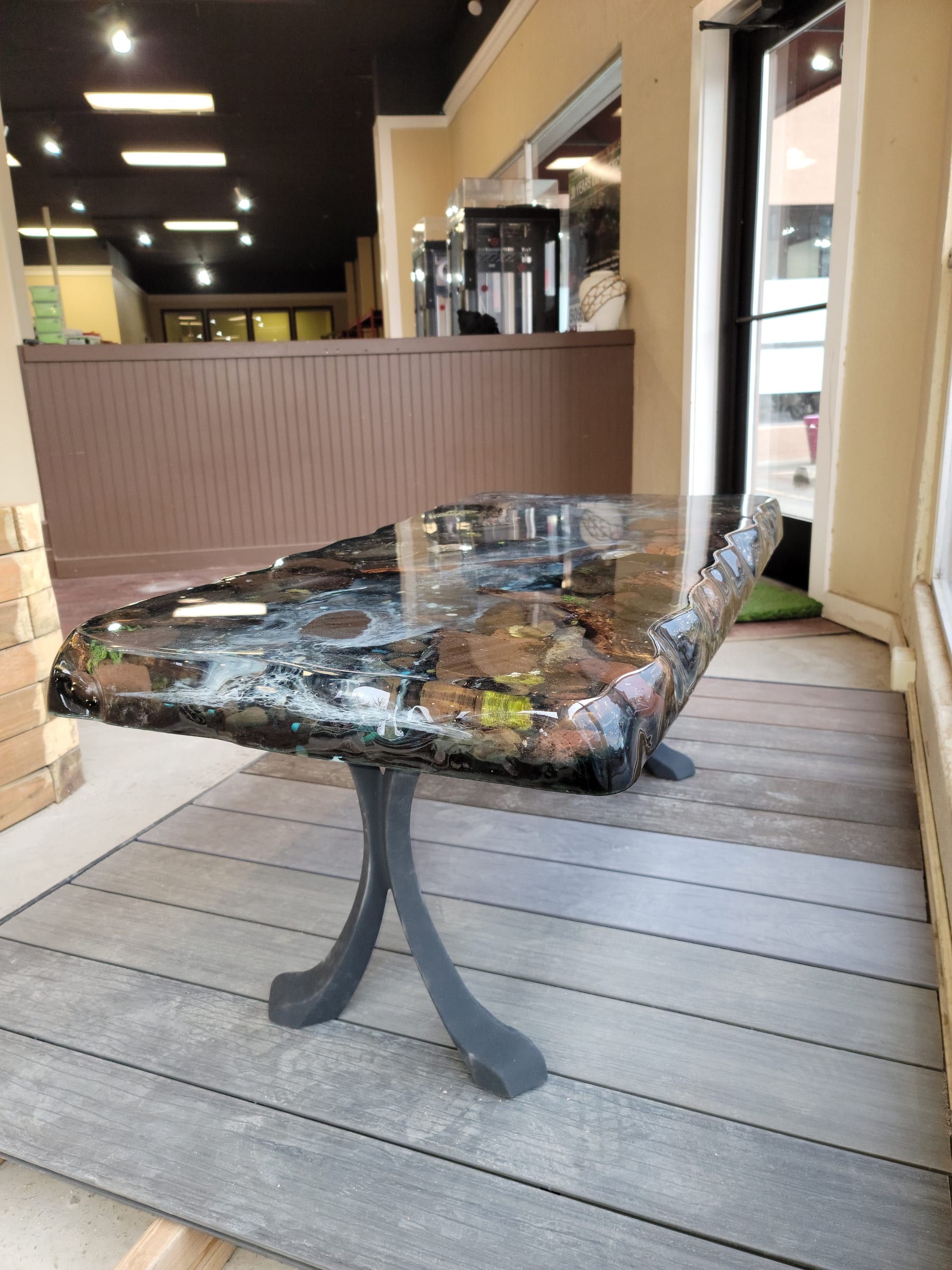 Live-edge coffee table with river stones and driftwood embedded in clear epoxy resin by Ray Sample