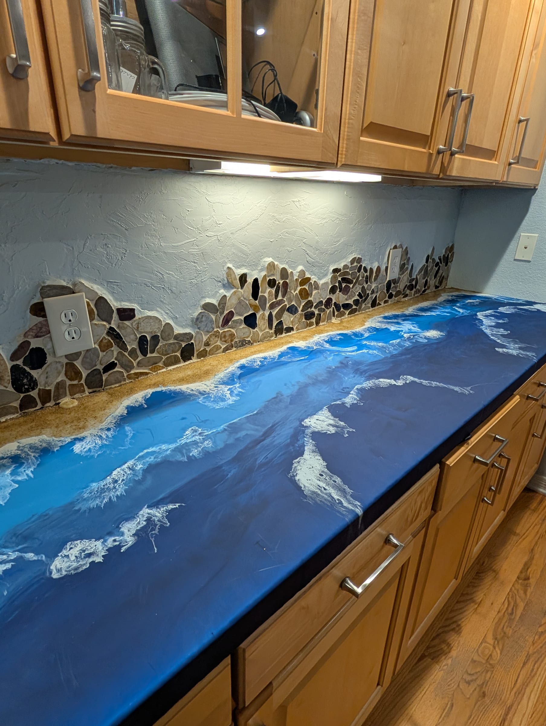 Deep blue ocean epoxy counter with hand-built river-rock backsplash by Ray Sample